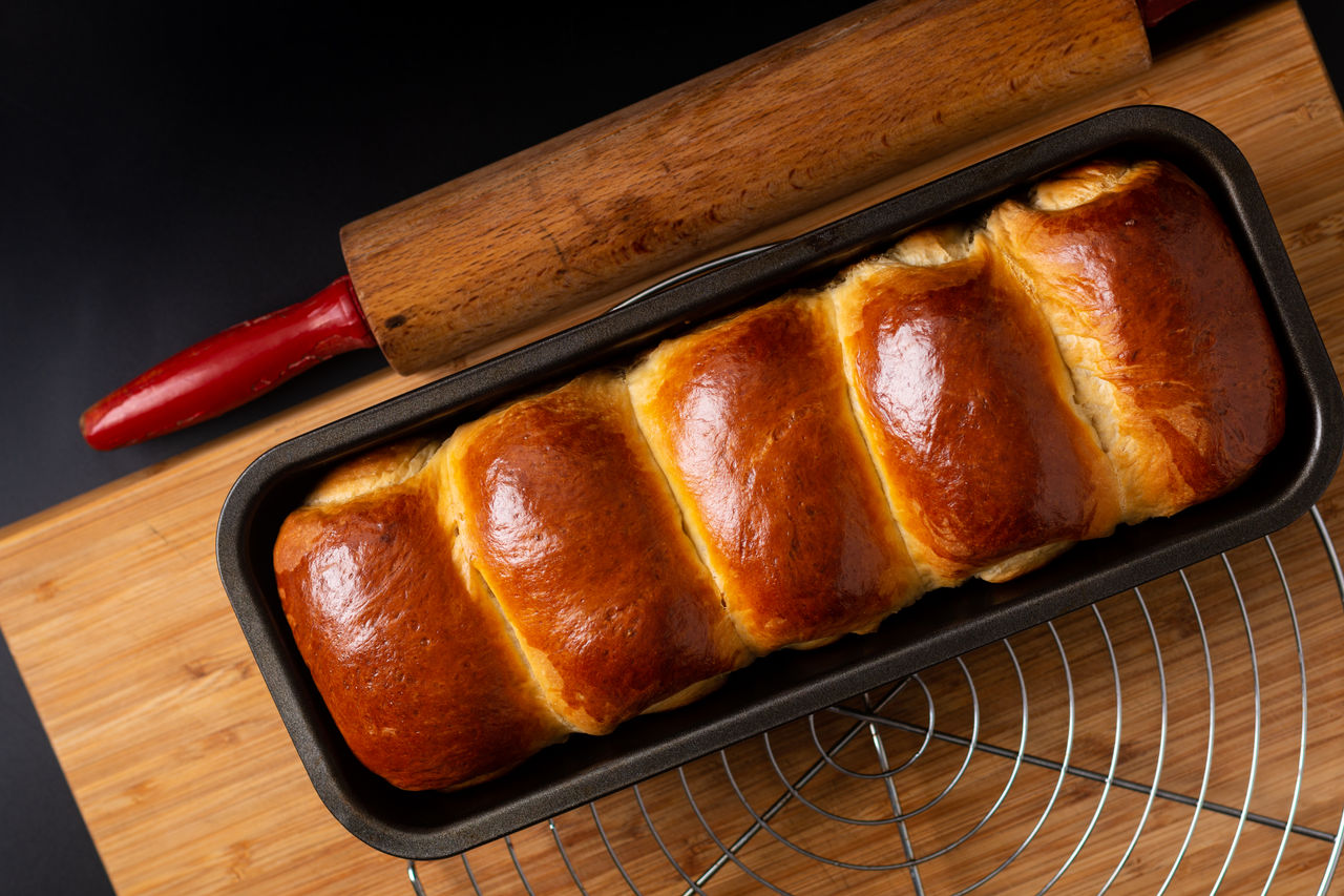 Food Baking concept Fresh baked organic homemade soft milk loaf bread in loaf pan on wooden board with copy space