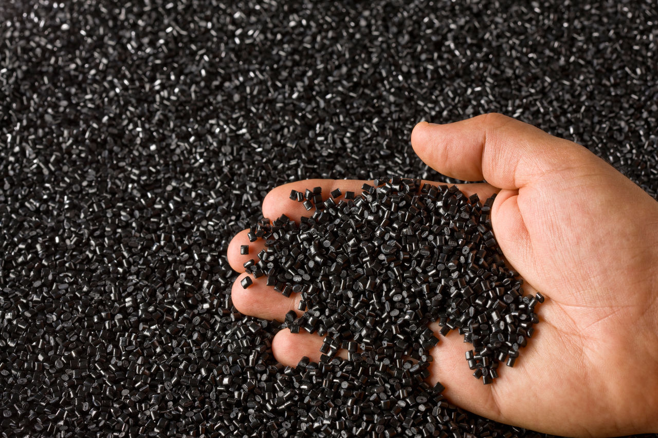 Plastic Black Resin Pellets in a Holding Hand
183261041