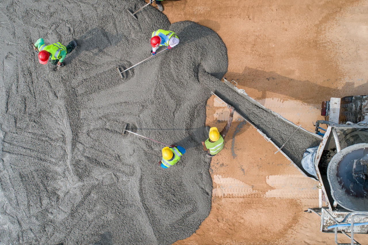 A construction worker pouring a wet concret at road construction site; Shutterstock ID 1553979806