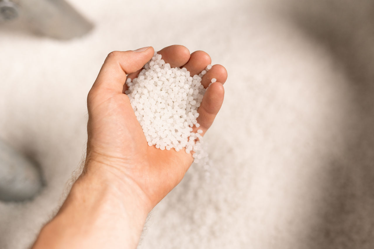 Hand of young male worker of large modern factory holding polymer granules; Shutterstock ID 1470308972; purchase_order: POL Website_masterbatch and compounds; job: ; client: ; other: 